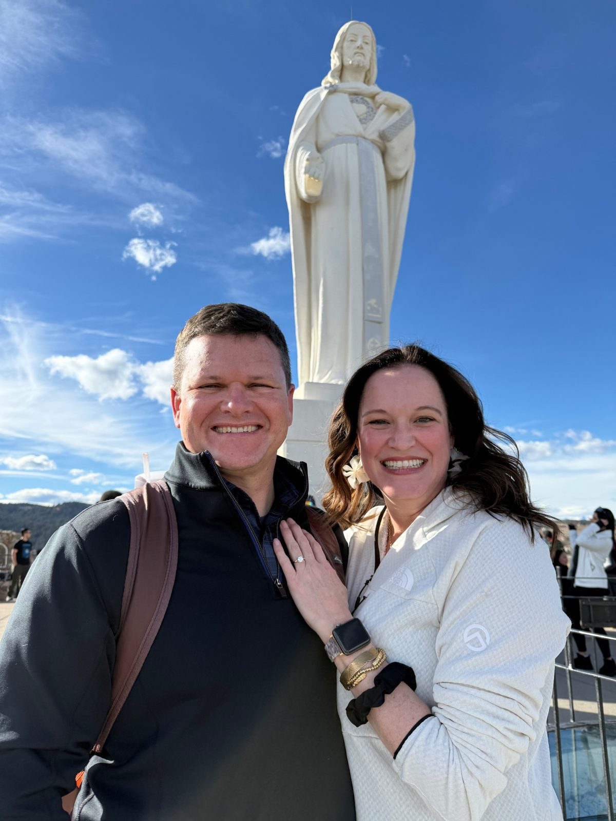 Julie and Jay showing off the engagement ring at the Christ of the Mines statue