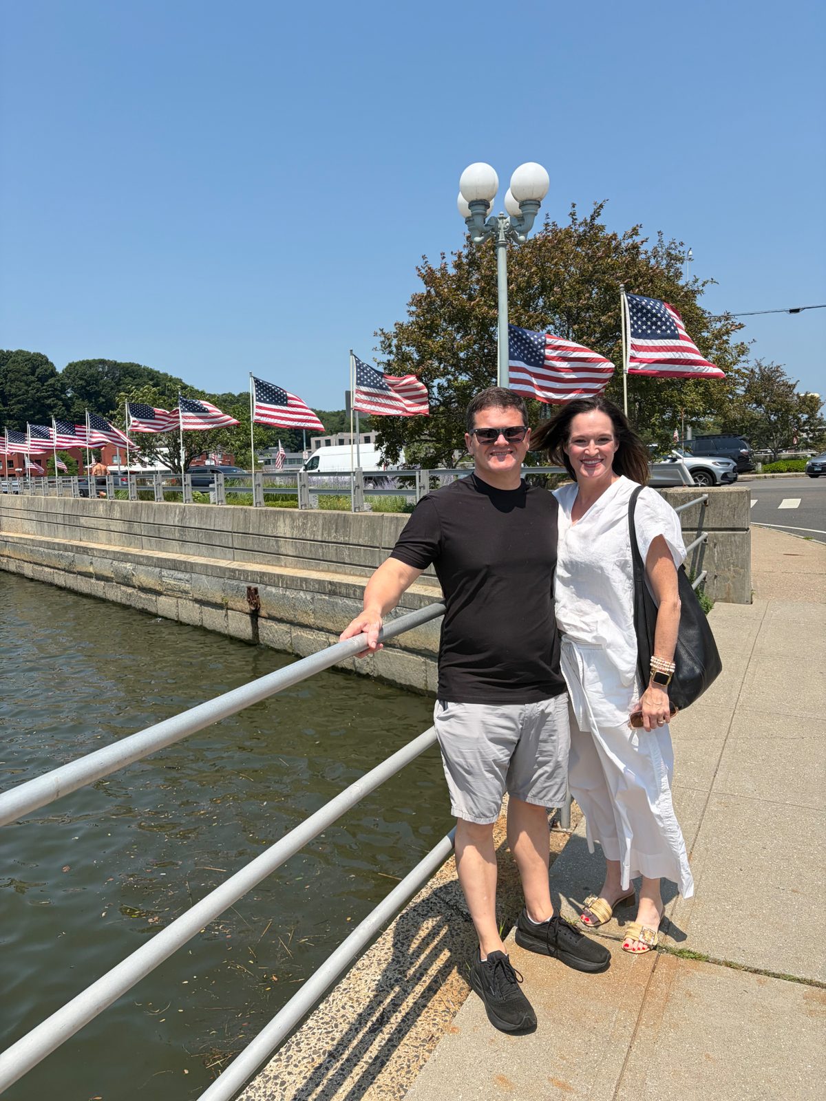 Julie and Jay along the waterfront with American flags