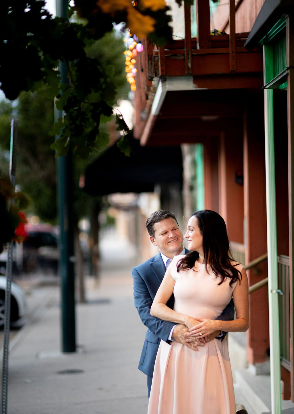 Julie and Jay embracing on a downtown sidewalk
