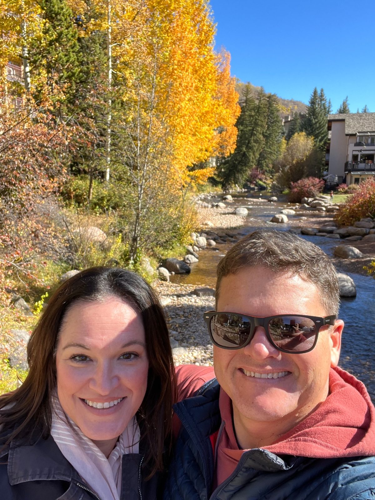 Julie and Jay by a mountain creek in Vail with autumn aspens