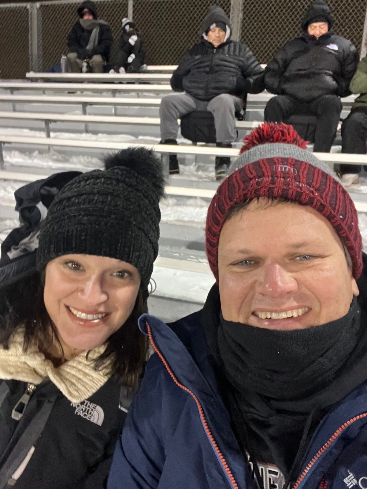 Julie and Jay bundled up at a snowy night football game