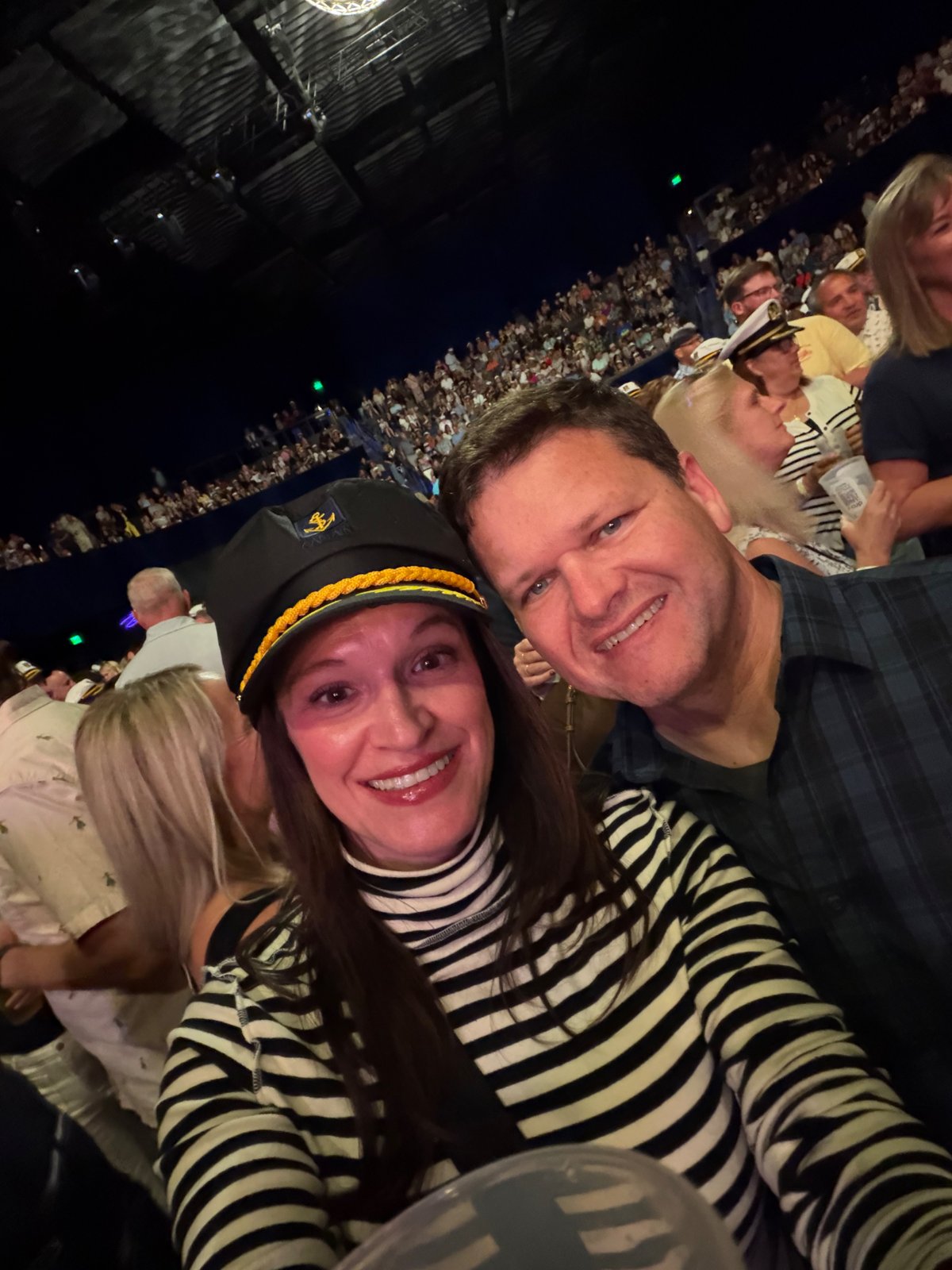 Julie and Jay at a nighttime concert, Julie wearing a captain's hat